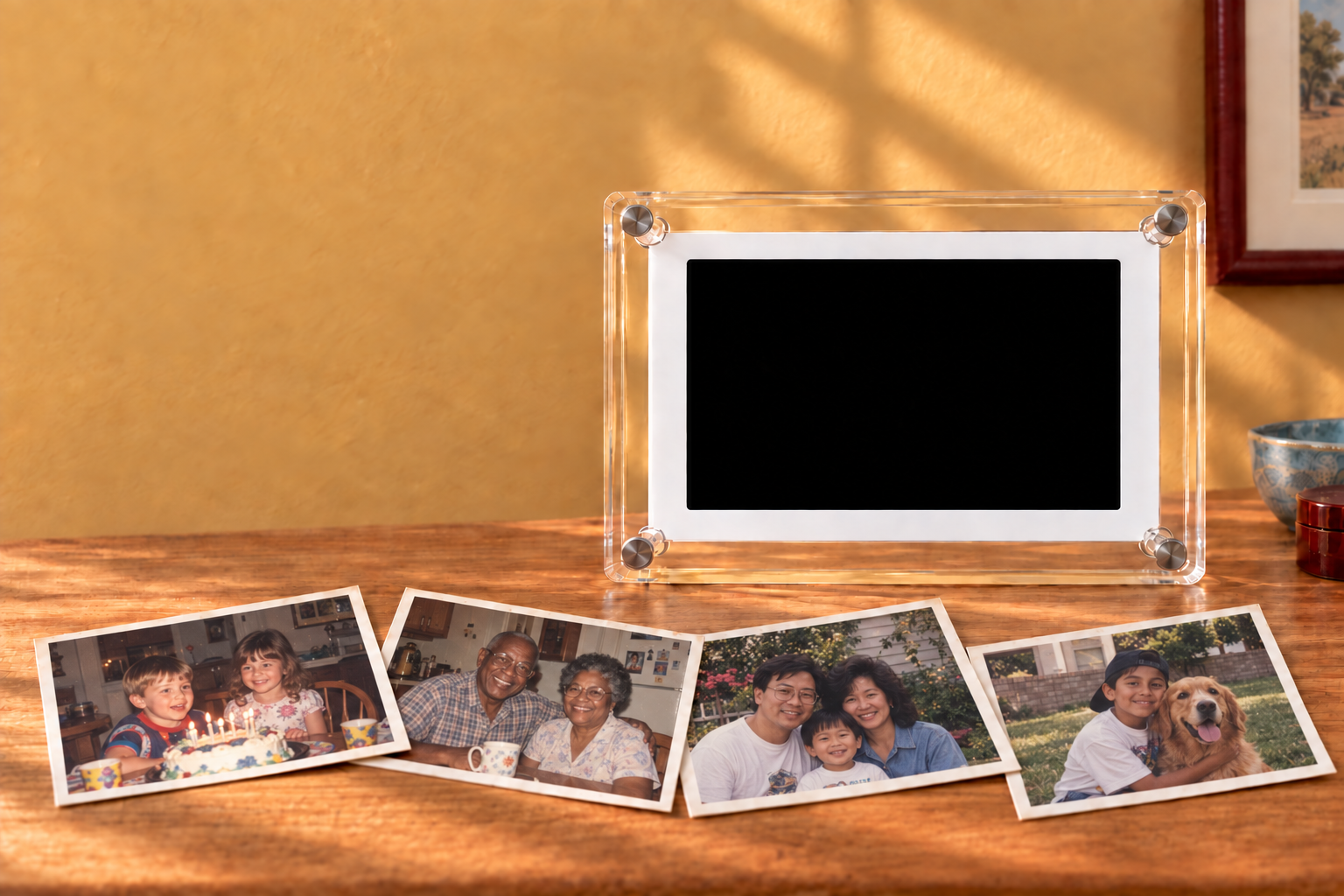 An acrylic Memovia frame standing on an oak table above four candid album prints of diverse families laid at relaxed angles across an oak table